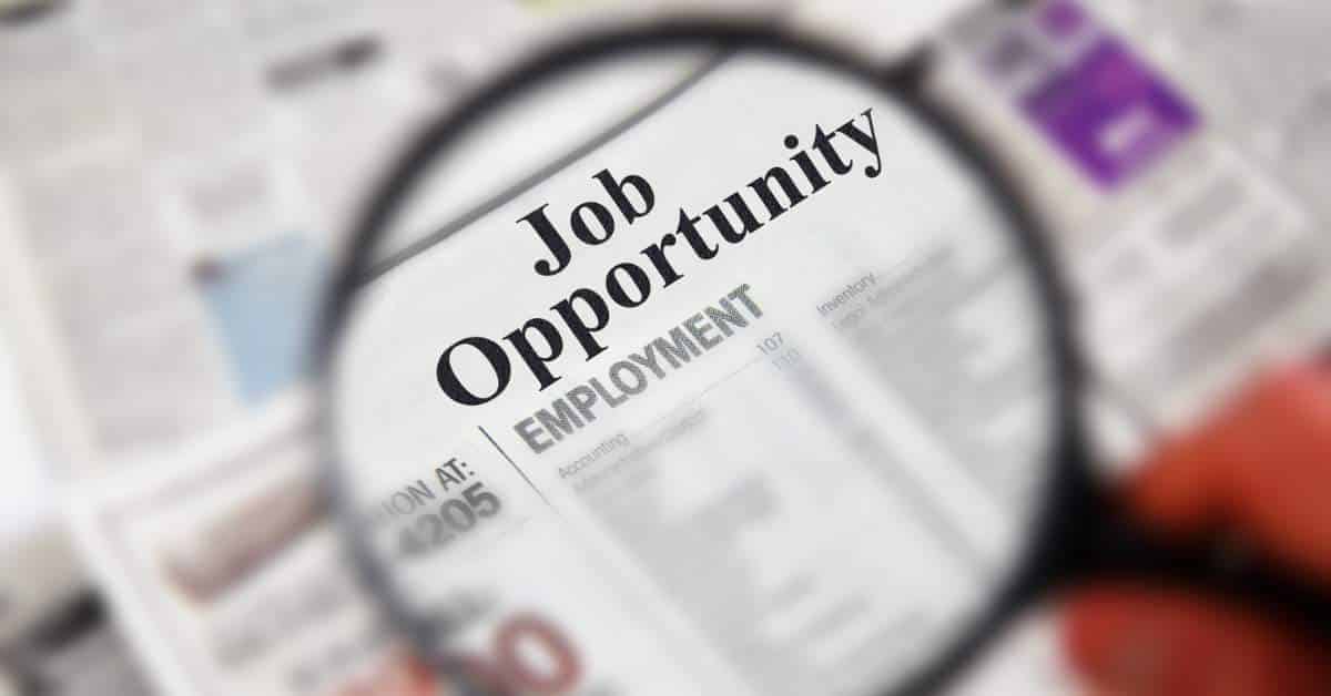 Newspaper print with "Job Opportunity" being examined under a micrscope