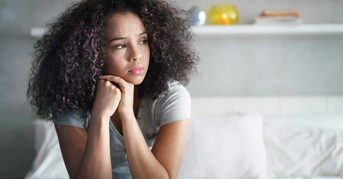African American teen girl looking pensively out the window