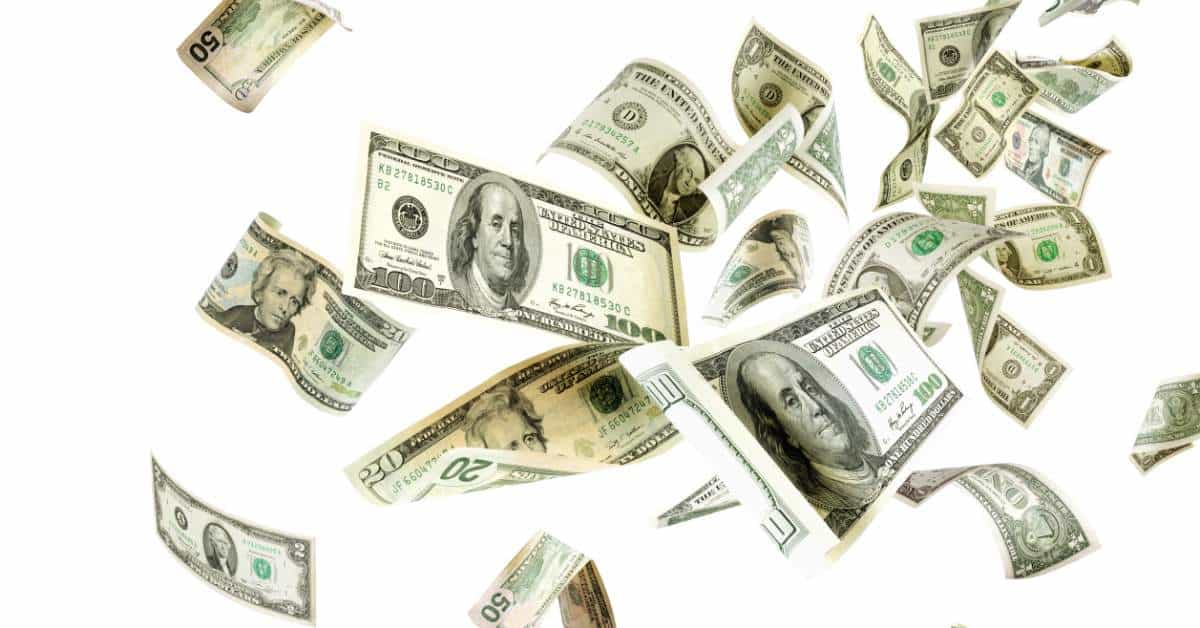Money flying away against a white backdrop