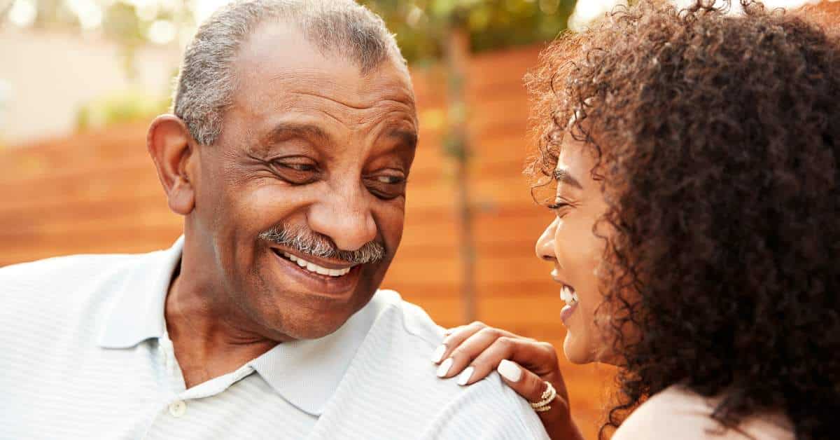 Grandfather smiling at teen granddaughter