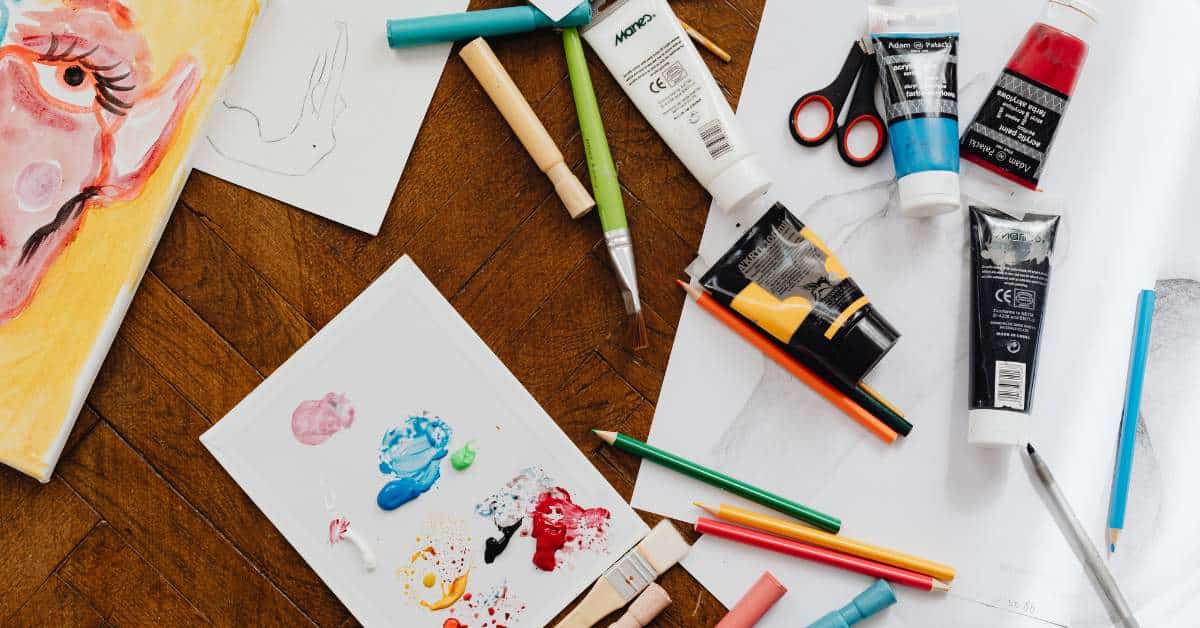 Paper and paints strewn on a table