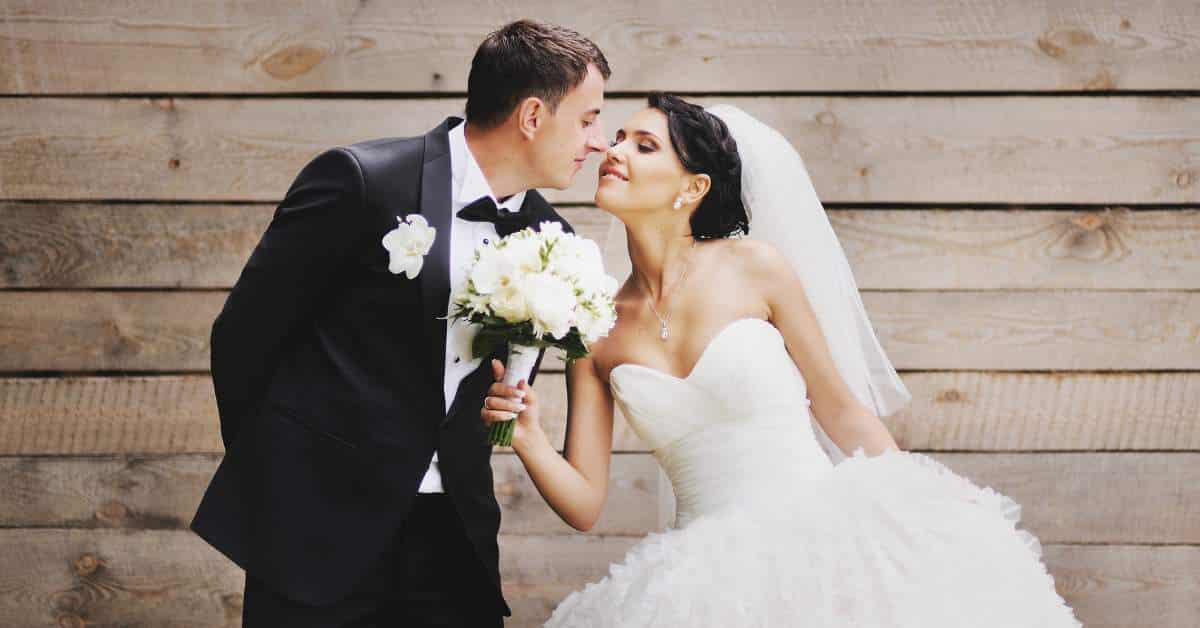 Happy bride and groom leaning in to kiss each other.