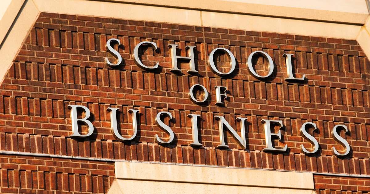 Top of a brick building that says "School of Business" in gold lettering.