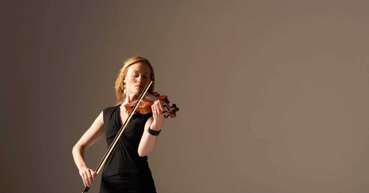 Woman wearing a black dress playing violin