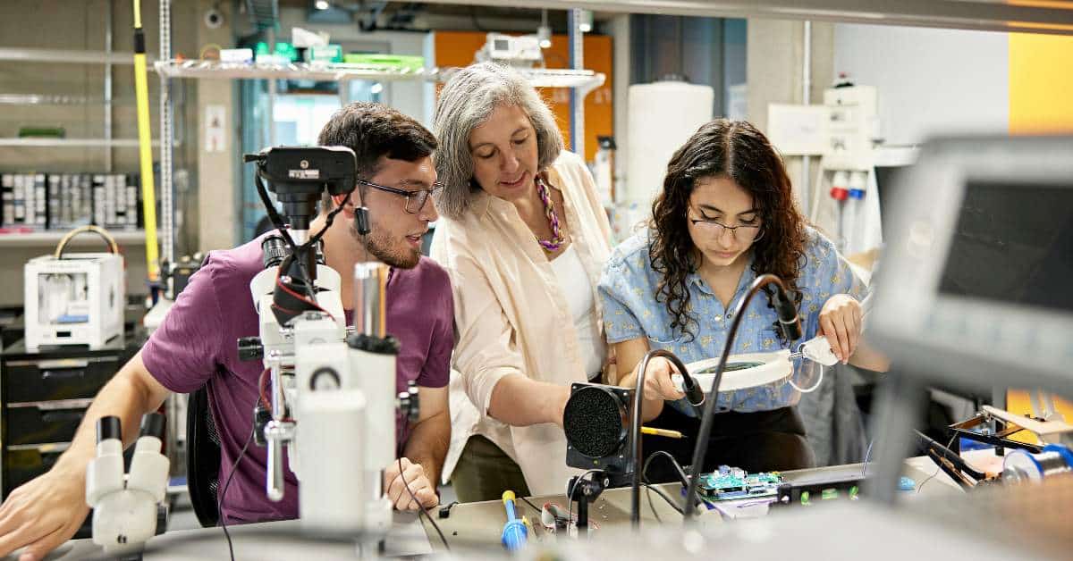 Two students and a teacher working on an engineering project